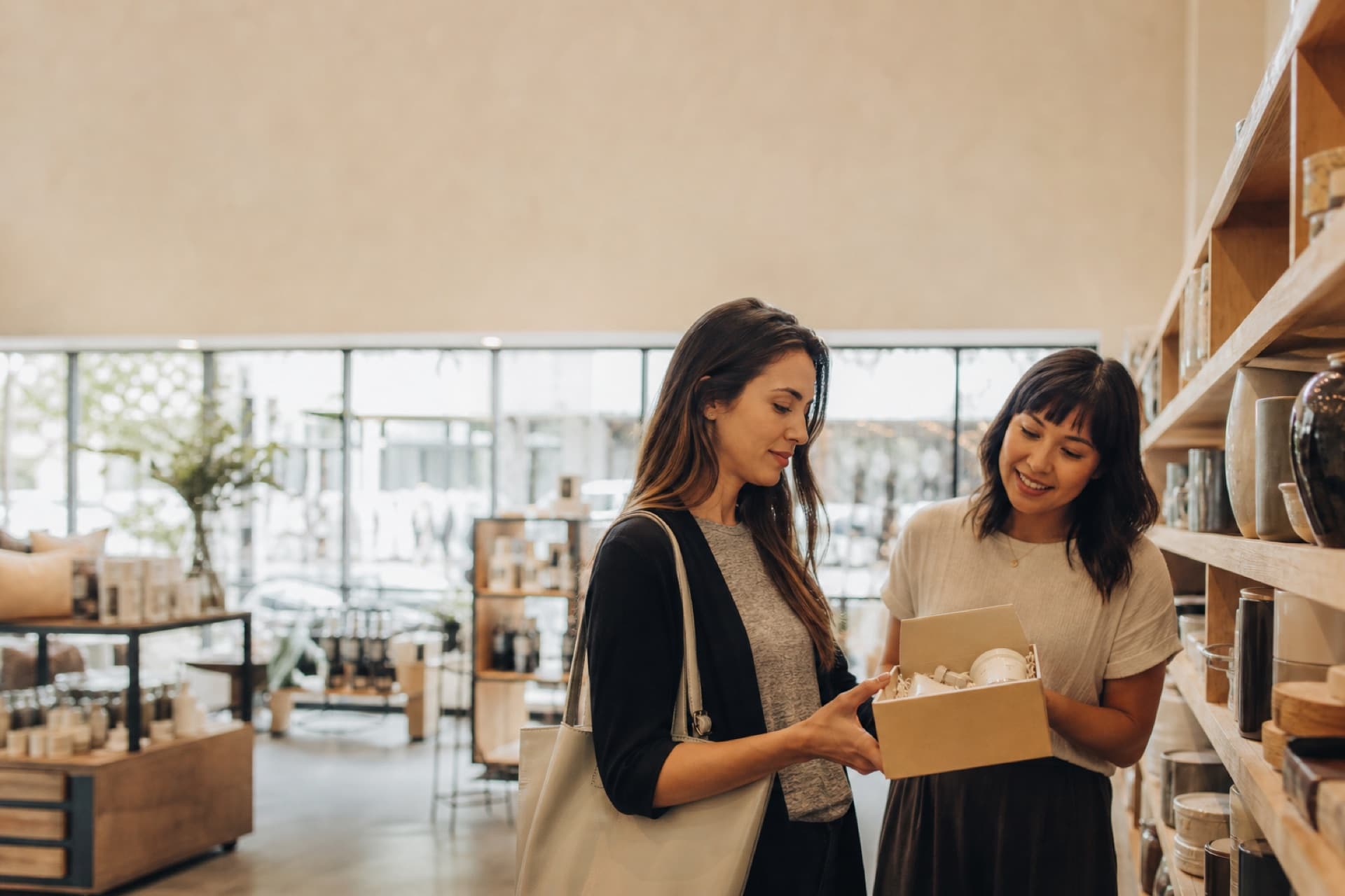 A shopper and shopkeeper looking at a curated box in a boutique