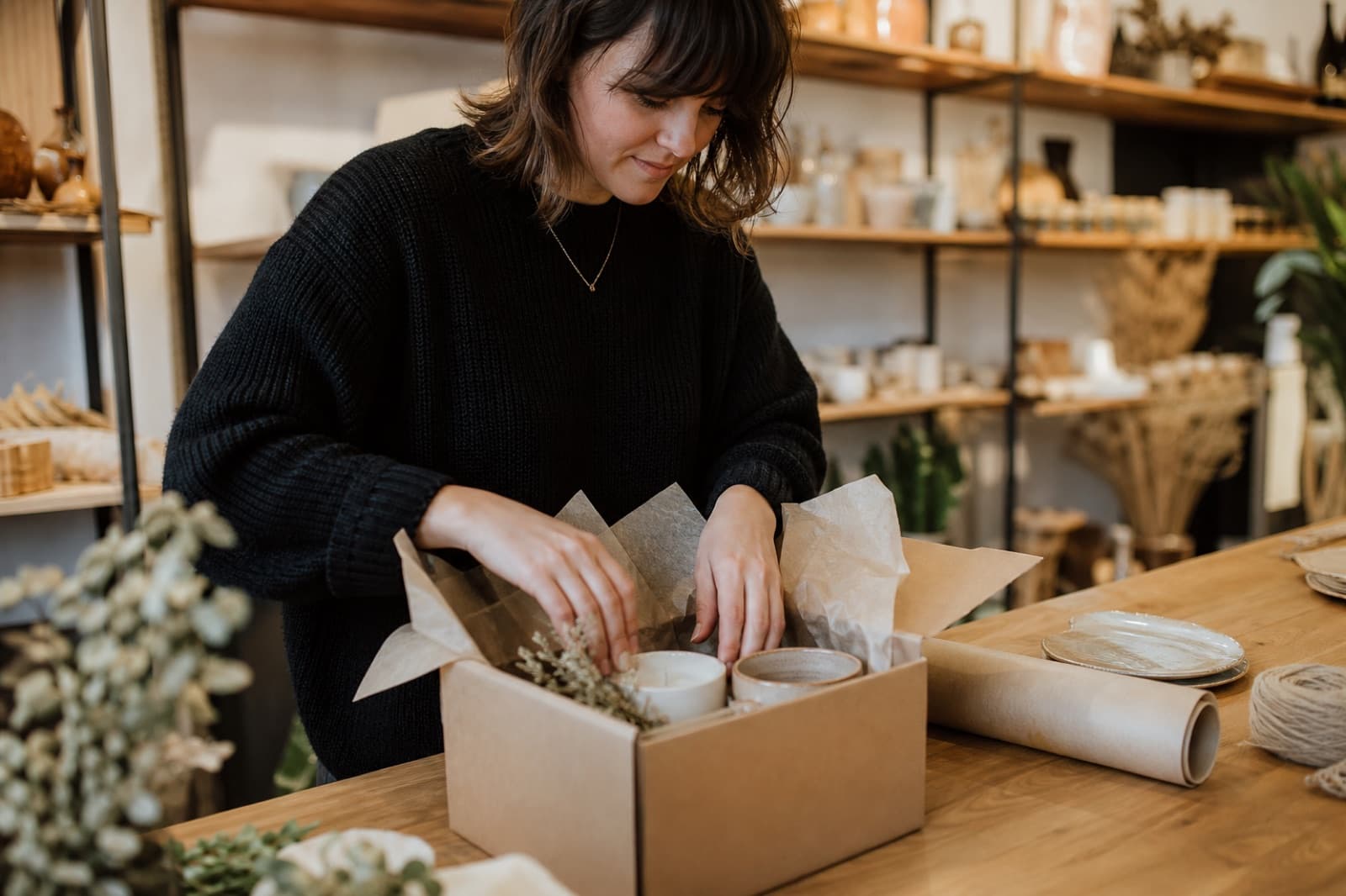 A boutique worker packing a curated subscription box